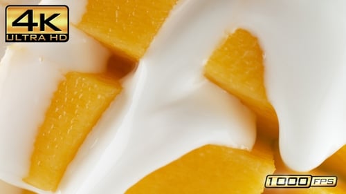 Close-up Fresh Mango Cubes Drizzled with Creamy Yogurt