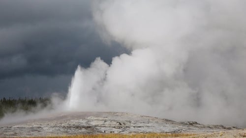 Spectacular eruption of Old Faithful Geyser in Yellowstone National Park, as steam and water erupt