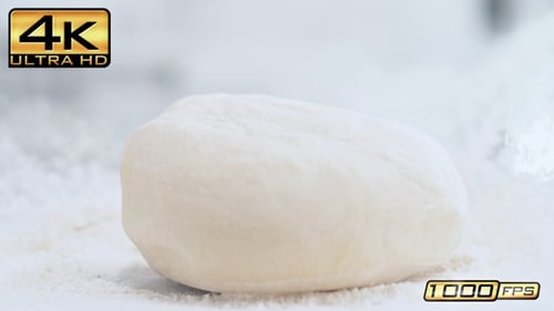 Dough Falling onto Flour Covered Surface in Slow Motion