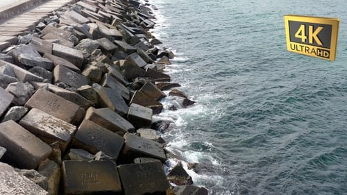Ocean Waves Crashing Against Sturdy Breakwater Wall