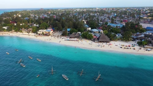Tourists enjoy a sunny afternoon on a beautiful Caribbean beach, swimming in crystal clear waters.