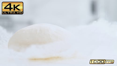 Dough Ball Falls onto Floury White Surface
