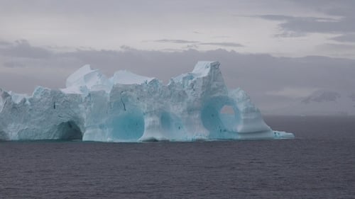 Giant iceberg floating in calm ocean waters showcases nature's beauty in a remote location