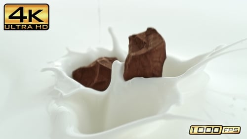 Chocolate Pieces Falling into Splashing White Milk Close-up