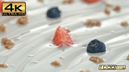 Yogurt with granola, strawberries, and blueberries being spooned