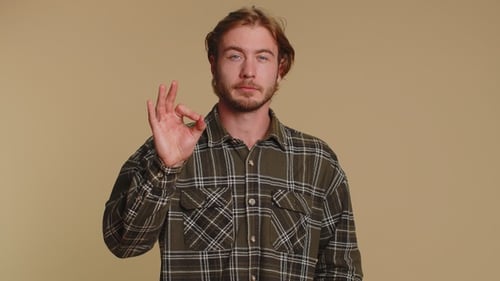 Young Man Giving OK Gesture in Studio