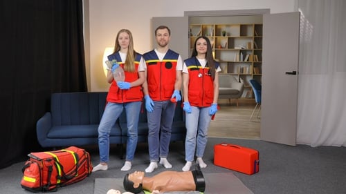 A group of young medical people in uniform stand in the middle of the classroom and smile