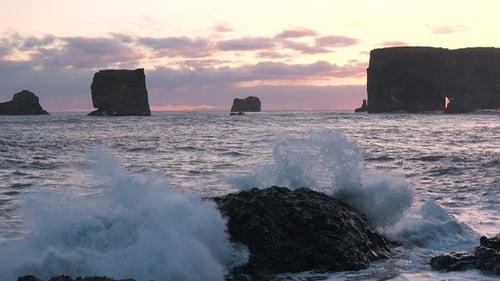 Large cliffs in the Atlantic Ocean. Iceland. The waves of the Atlantic Ocean. Black volcanic cliffs.