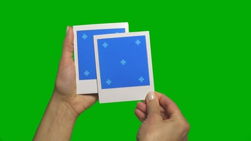 Hand Holding Photos on Green Screen