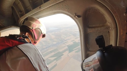 Frau springt mit einem Fallschirm aus einem Flugzeug. Standpunkt.