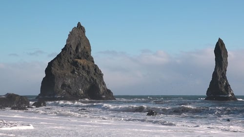 Meereswellen zerquetschen die Kieselfelsen des Strandes in Island. Spritzer Seesturmwasserschaum
.
