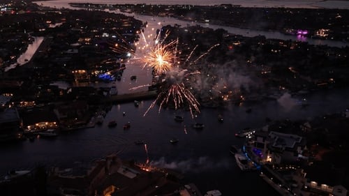 Nighttime Fireworks over Waterfront Homes in City