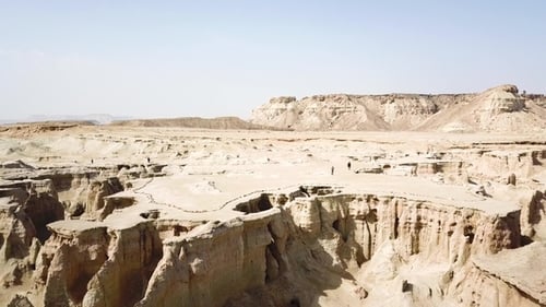 Erkunden Sie mittags eine weite Wüstenlandschaft mit einzigartigen Felsformationen und fernen Hügeln