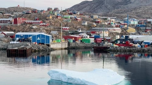 Colorful houses on rocky shore in Greenland under clear blue sky