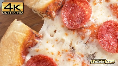Tearing A Slice Of Pepperoni Pizza in Slow Motion, Table Top View Of Stretchy Mozzarella Cheese