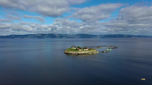 Beautiful island surrounded by calm waters featuring vibrant greenery and historical buildings.