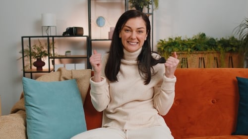 Cheerful Woman Giving Thumbs Up on Couch