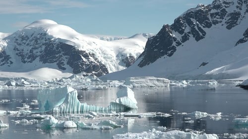 Beauty of Antarctica with majestic ice formations and waters reflecting the sky. Climate change.