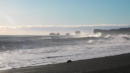 Large cliffs in the Atlantic Ocean. Iceland. The waves of the Atlantic Ocean. Black volcanic cliffs.
