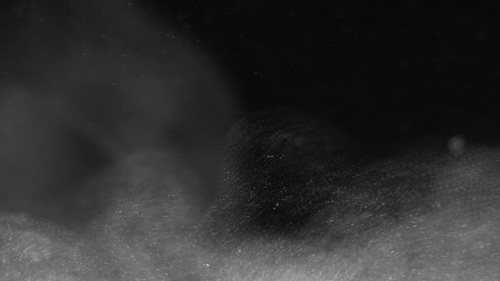 Gray Dust Particles Rising on Black Background