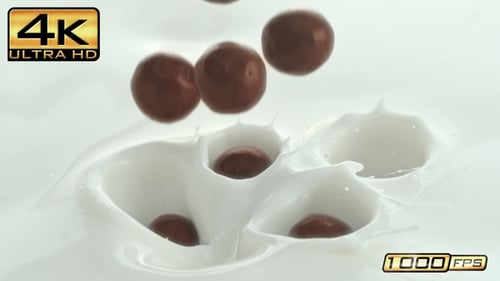 Round Chocolates Dropping into Creamy Liquid with Splash