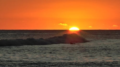 Colorful sunset in Hawaii. Tropical sea sunrise and waves on exotic beach.