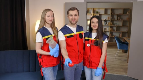 A group of young medical people in uniform stand in the middle of the classroom and smile