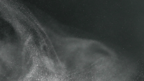 Dust Particles Swirling Against a Dark Gray Background