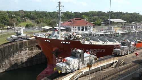Panama Canal. Cargo ship and containers passing through locks between the Atlantic and Pacific Ocean