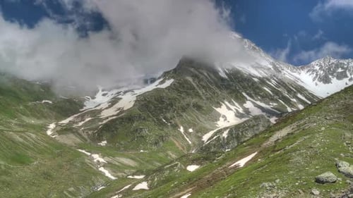 8K Glacial Valley and Alpine Meadow in Front of Rocky Mountain Peaks