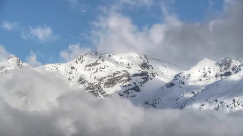 8K Imposing High Snowy Mountain Peaks Behind the Clouds