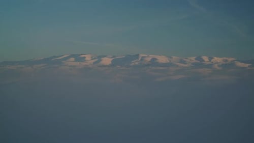 Aerial View of Snowy Mountains at Sunset