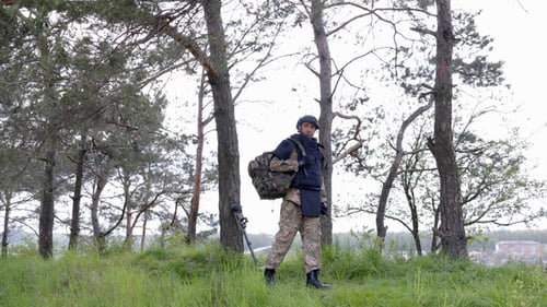 Soldier in uniforms works in the forest and prepares for action at a temporary forest base