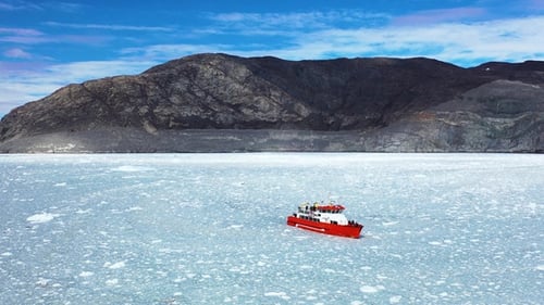 Boote schwimmen in der gefrorenen Winterwasserlandschaft an der Eisküste. Ausflugsboot umgeben von Eisbergen
.