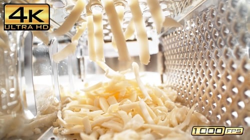 Fresh Cheese Falling from Grater in Kitchen