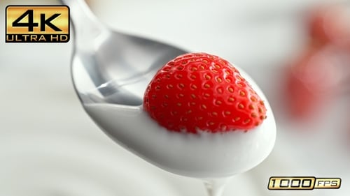 Strawberry in Yogurt Being Lifted by Spoon
