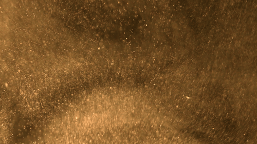 Gold swirl of sandy dust particles rise up