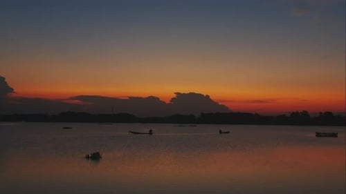 Tranquil Sunset Over Water with Boats