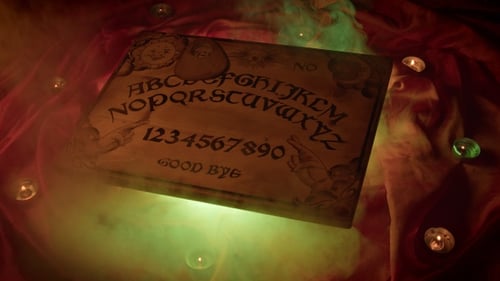 Spirit Board Surrounded by Candles and Green Fog