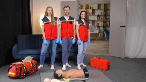 CPR Trainers Posing with Dummies and First Aid Kits