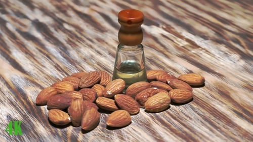 Almond Oil with Almonds on Wooden Surface