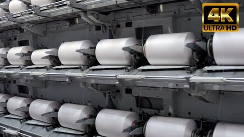 Factory Yarn Spools Spinning on Industrial Machinery