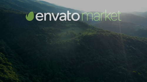 Aerial view of farm fields surrounded by high mountains covered with green trees