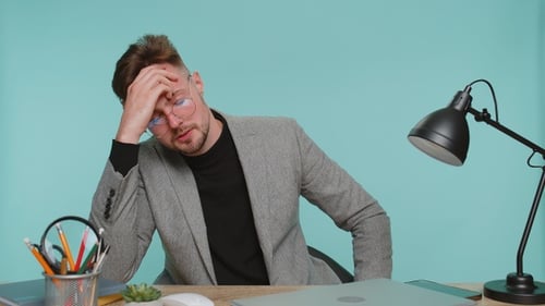 Frustrated Young Adult Working on Laptop in Office