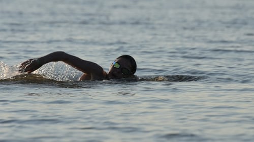 Niña nadadora nada al estilo de natación libre en el mar. Cámara lenta.