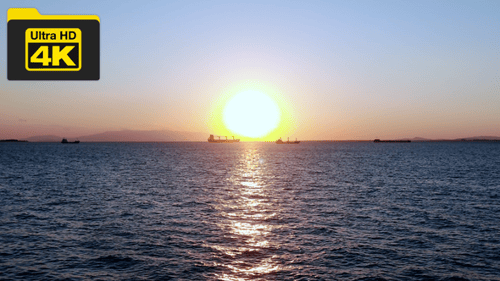 View of the sea and distant ships over the sea waves at sunset in the evening