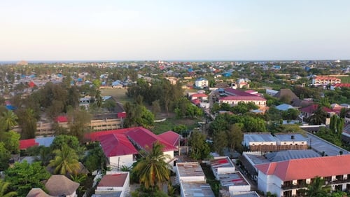 Aerial perspective captures a bustling coastal town with colorful buildings and beautiful ocean.