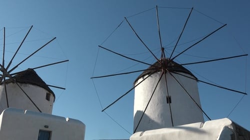 Windmill by the ocean. Historic traditional Azores windmill. Blue sky and clouds behind windmill.