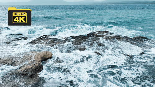 Aerial view of sea waves hitting the rocks with drone