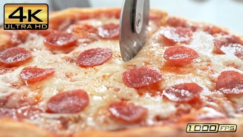 Slicing Pepperoni Pizza with Pizza Cutter in Home